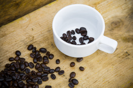 Coffee beans background on wooden, Fresh coffee beans with coffee cup on wooden background, Drinking set background.の写真素材