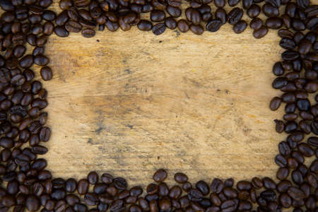 Coffee beans background on wooden, Fresh coffee beans with coffee cup on wooden background, Drinking set background.の写真素材