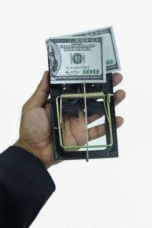 Trap with dollar bills isolated over white background, Risk in business, Businessman taking money from a mousetrap.の写真素材
