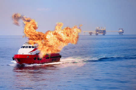 Fire burning on the boat in offshore oil and gas industry, emergency case and firefighter working for protection boat and working area.の写真素材
