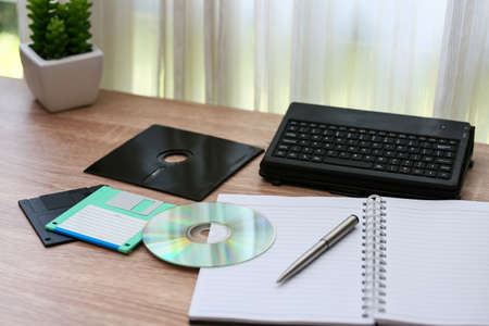 desk with note ,floppy disk A, floppy disk B and memory drive in home office, private office and modern desk in modern life, online market and planning for work, document and paper on desk.の写真素材