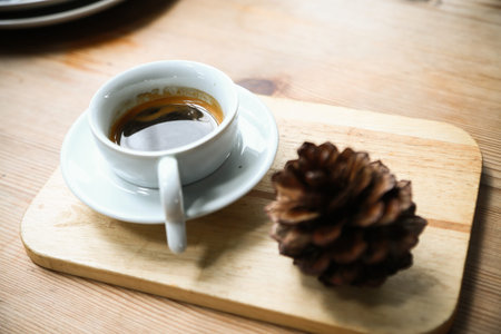 Black coffee in white cup on wooden board
