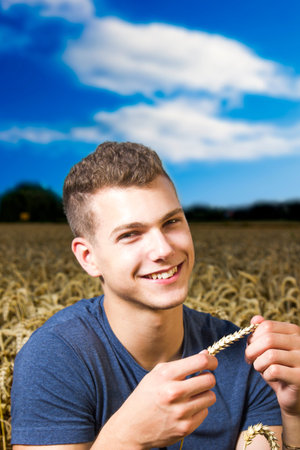 Young farmer looking at the return bringing harvestの写真素材