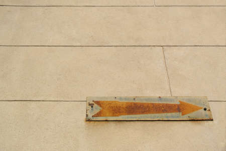 Rusty vintage old arrow sign on wallの写真素材