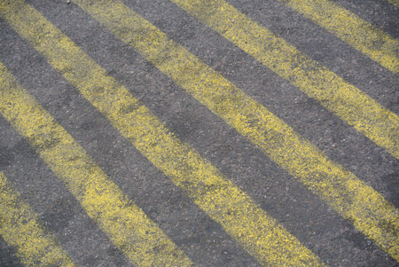 Yellow stripes painted texture on asphalt