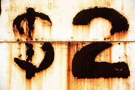 Photo of burned two dollar sign over rusty eroded wallの写真素材