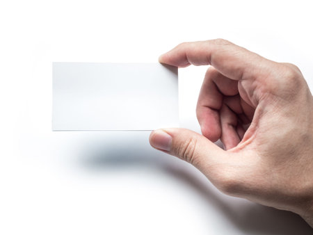 Close up of hand holding business card on the white wall