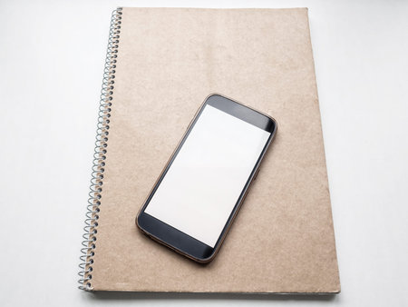 Mockup of Modern smartphone with white blank screen on notebook cover