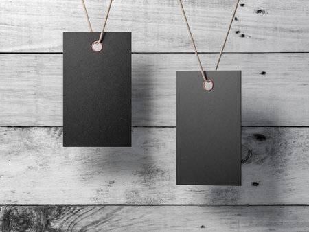 Two Black Empty tags label Mockup tied on cord on wooden wall backgroundの写真素材