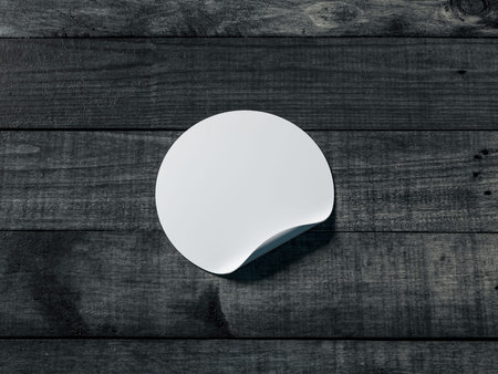 White round adhesive sticker mockup on black wooden table