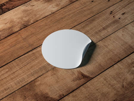 White round adhesive sticker mockup on wooden tableの写真素材