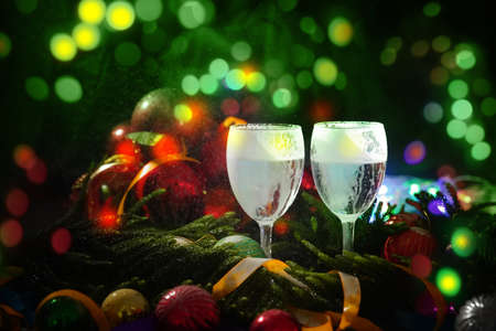 Two glasses of champagne with a Christmas decor in the backgroundの写真素材