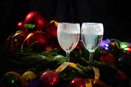 Two glasses of champagne with a Christmas decor in the backgroundの写真素材