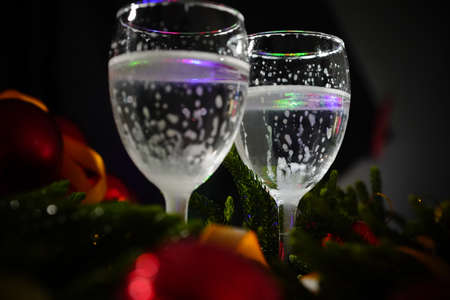 Two glasses of champagne with a Christmas decor in the backgroundの写真素材