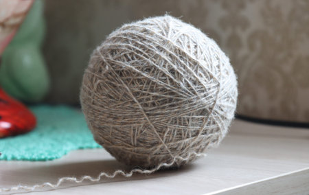 A ball of woolen thread lying on the tableの写真素材