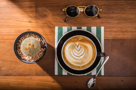 Coffee latte foam arts in heart shape top view with porps by stylist, lay on wood table.の写真素材