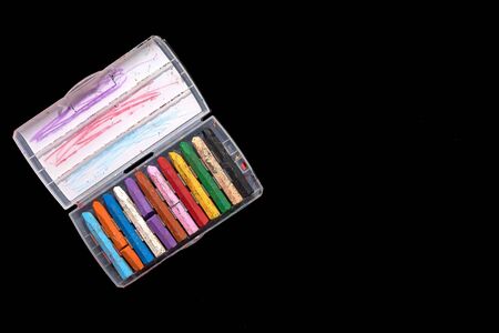 top view colorful of crayons in box after use for drawing, isolated on black background.の写真素材