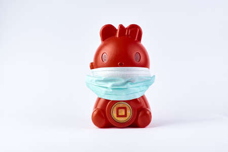Red Piggy bank wear medical mask isolated on white.の写真素材