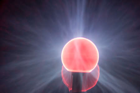 Electric red and blue retro plasma light ball with red and blue surges of lightの写真素材