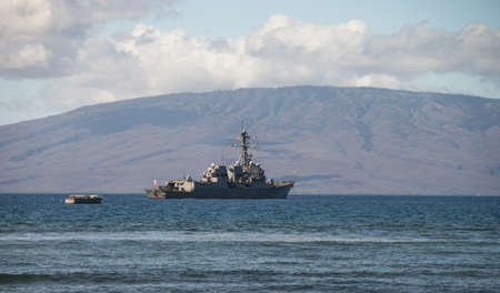 United States Navy Ship anchored off the coast of Maui, Hawaii.  The island of Lanai in backgroundのeditorial素材