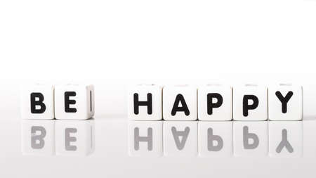 Be Happy spelled in black letters reflected on white backgroundの写真素材