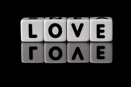 Love spelled in dice with the word hate reflected on white isolated backgroundの写真素材