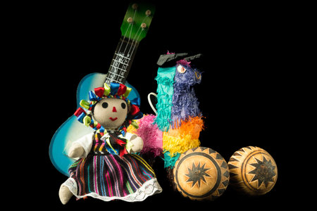 Mexican doll, pinata, guitar, hat, and maracas isolated on black background