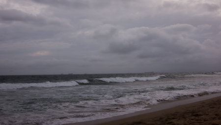 Dark stormy clouds and large waves crashing on the beach