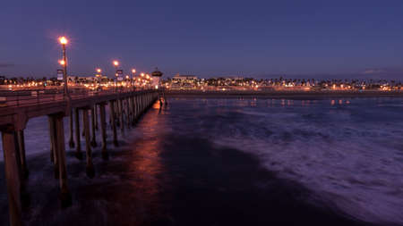 City lights and slow moving waves under the Huntington Beach Pier at twilightの写真素材
