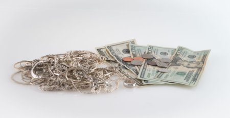 Concept image "cash for silver" with US money and scrap silver on white backgroundの写真素材