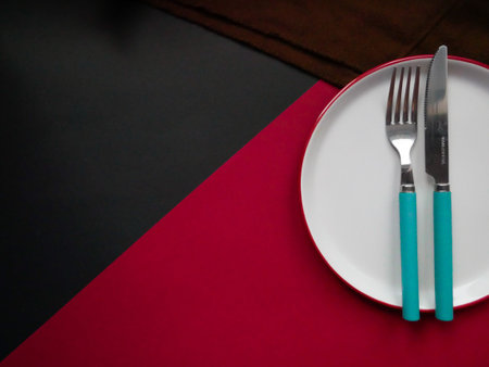 Cutlery set with plate. Dish, fork and knife, copy space, colored background, closeup, top view