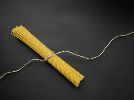 sheaf raw spaghetti on a black background isolated