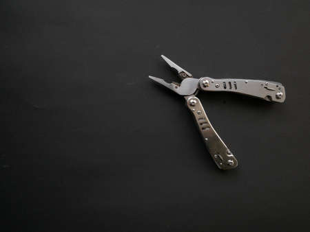 Multi tool with steel handles on a black paper background. Top viewの写真素材