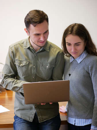 Two colleagues discussing their project. Office workers work on laptopの写真素材