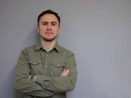 Portrait of young man with crossed hands in officeの写真素材