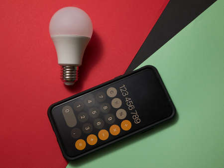 USA, May, 2020. Calculator app on iPhone 11 pro with light bulb on a colored background.のeditorial素材