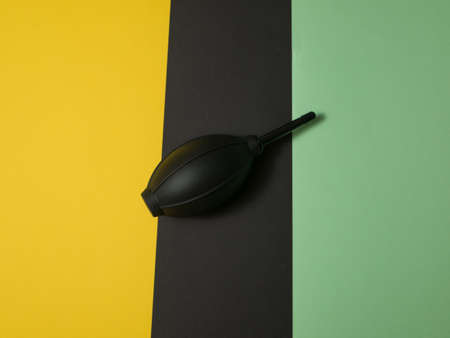 Black rubber air blower pump dust cleaner isolated on colored background.の写真素材