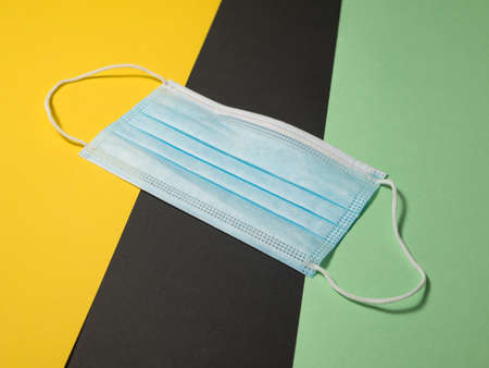 Disposable face mask for Corona on colored background with text free space.の写真素材