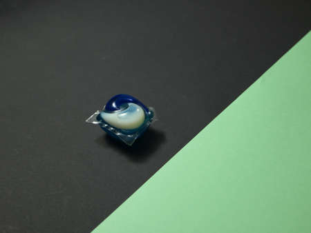 Washing powder for colored laundry in a capsule. isolated on colored background.の写真素材