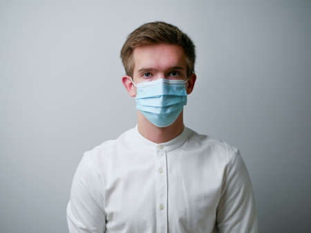 Man wearing a protective face mask against coronavirus. Medical staff preventive gear. white background.の写真素材