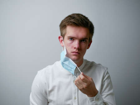 Man wearing a protective face mask against coronavirus. Medical staff preventive gear. white background.の写真素材