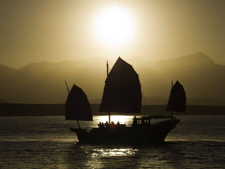 An oriental sunset cruise comming back into port.の写真素材