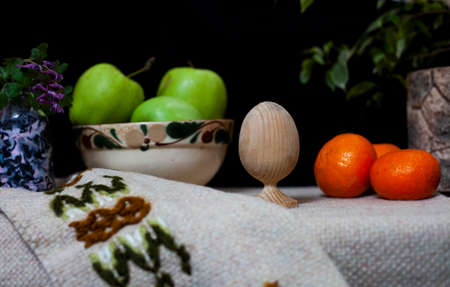 Still life of green aples, tangerines and woden eggの写真素材