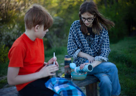 Boy and girl teenagers eating on a picnic in natureの写真素材