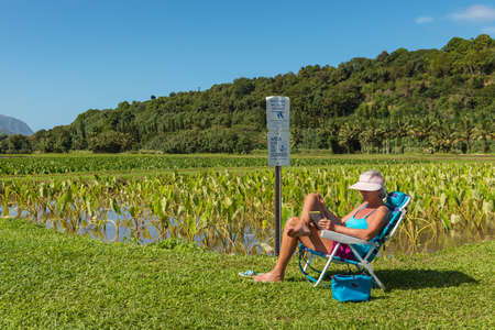 KAUAI, HAWAII, USA-DECEMBER 29, 2014: Female tourist relaxing within taro fields hanalei valleyのeditorial素材