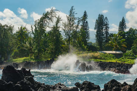 coastal view of the shore line with its black volcanic rocks and cliffs at hana maui hawaiiの写真素材