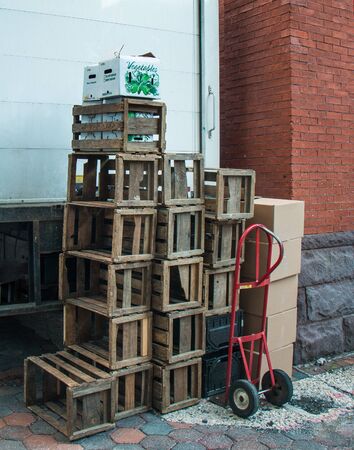 Empty wooden fruit and vegetable crates with a hand cart in front of a truck at the Lancaster Farmers' Marketの写真素材