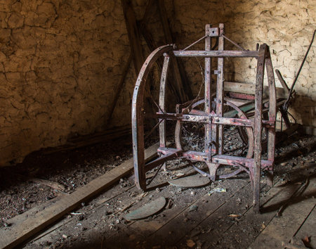 Rough-hewn interior of an old wooden barn in eastern Pennsylvania with antique farm implementsの写真素材