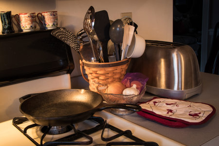 Interior shot of ordinary kitchen implements on and next to a gas range