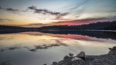 Early morning at Blue Marsh with wispy clouds above a tranquil lakeの写真素材